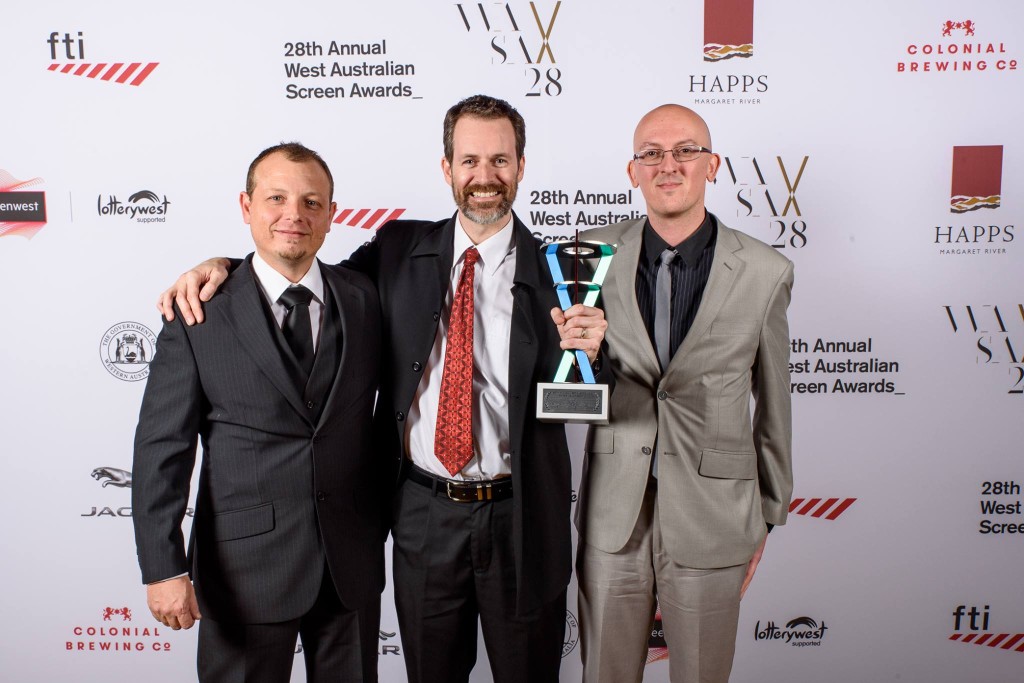 Anthony Carriero, Paul Turbett, and Anthony Sweet standing together, with a WASA Award