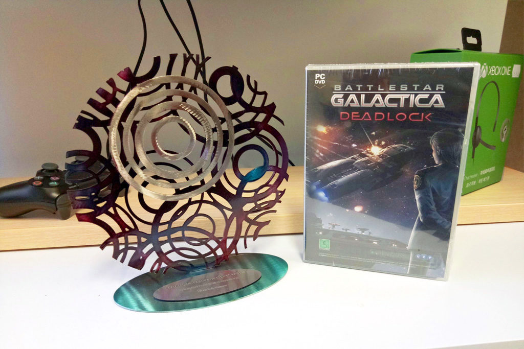 A photograph of a 2017 Australian Game Developer Award sits next to a PC copy of WA-made game Battlestar Galactica Deadlock
