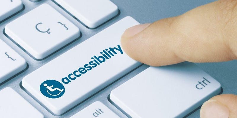 A finger pressing a keyboard button labelled "accessibility"