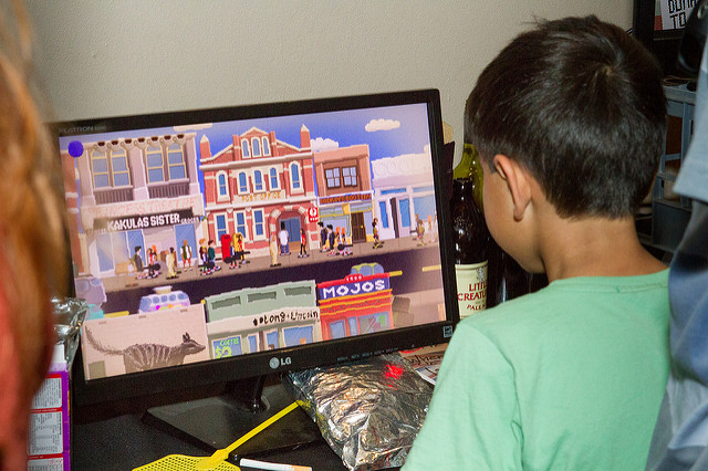 A young boy plays a game that features a cartoony street that looks a lot like Fremantle